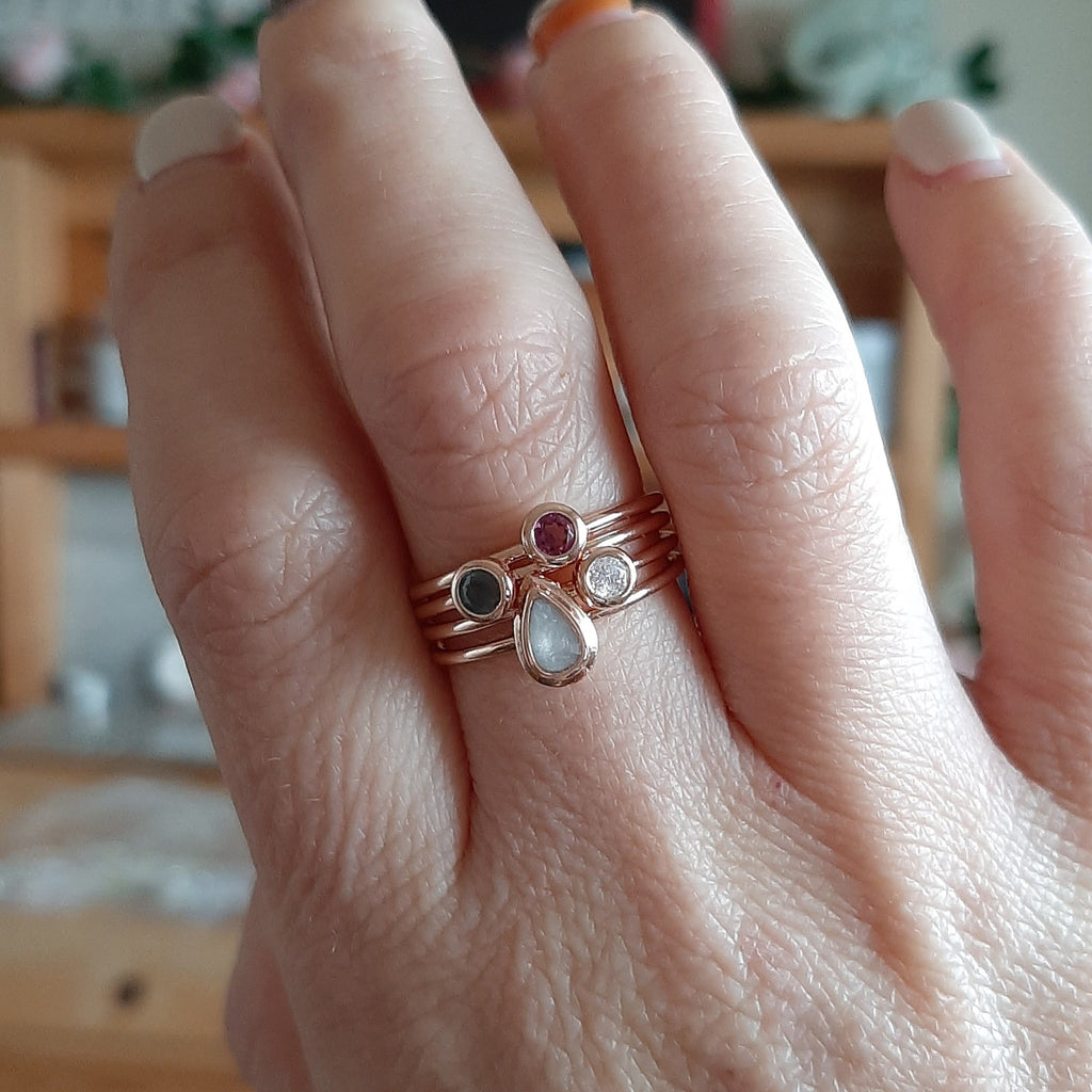 Breastmilk stacking ring with birthstones on a mum’s finger. This stackable mothers ring symbolises the birth of her three children and their breastfeeding journey.